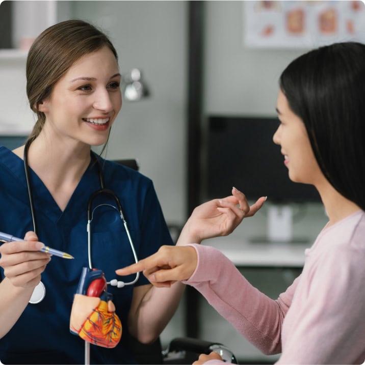 Infirmière montrant un modèle de cœur à une patiente