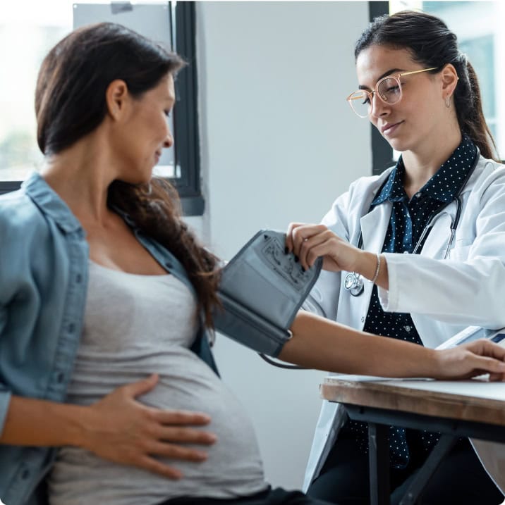 Médecin mesurant la tension d’une femme enceinte