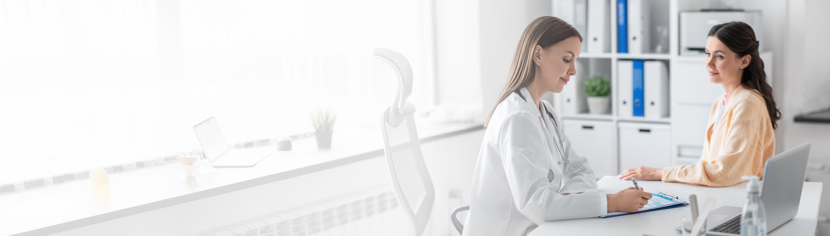 Médecin prenant des notes face à une patiente