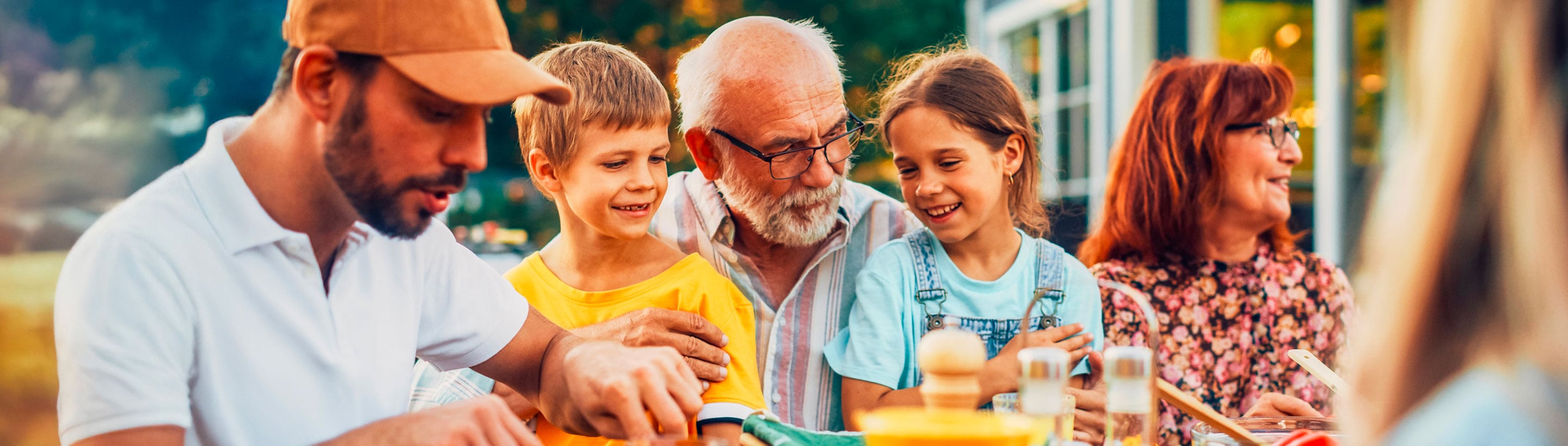 Famille de plusieurs générations partageant un repas en plein air