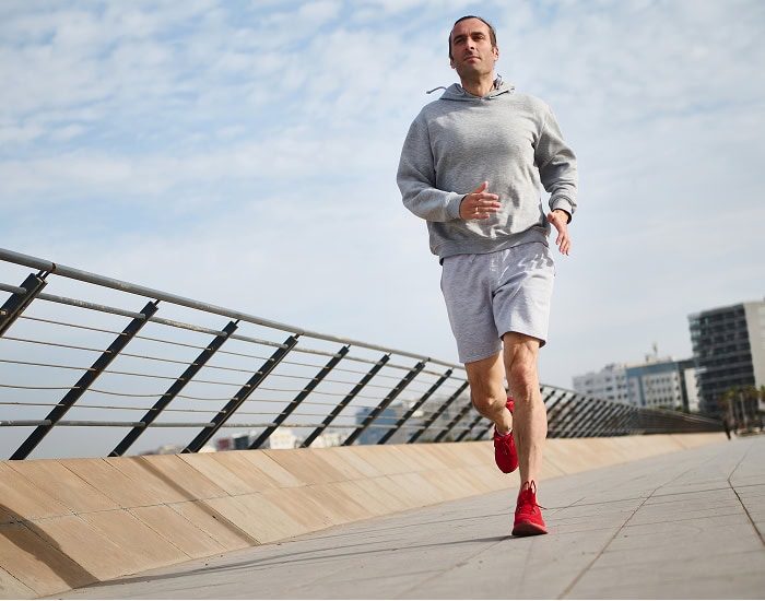 Homme courant sur une promenade urbaine